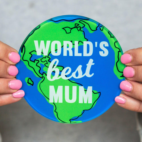 A round glass coaster with an illustration of the world and the words 'World's Best Mum'