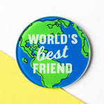 A round glass coaster with an illustration of the world and the words 'World's Best Friend'